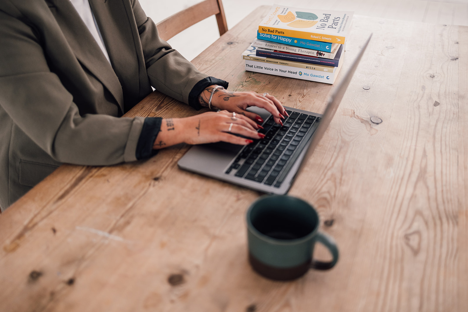 hands typing on laptop keyboard while sitting at a desk