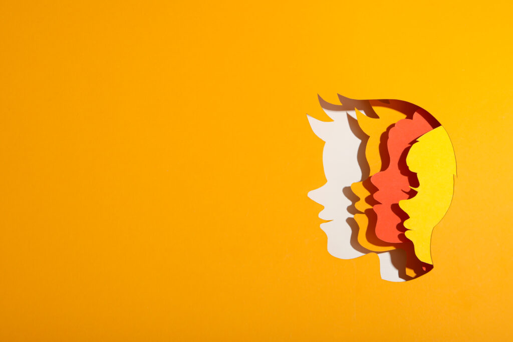 paper cut outs of faces stacked on one another